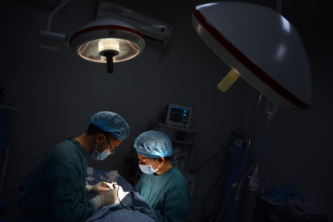 Dwóch lekarzy wykonuje operacje w szpitalu w Chongqing w południowo-wschodnich Chinach 9 sierpnia 2013 r. (Peter Parks/AFP/Getty Images)
