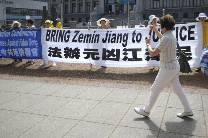 Kobieta pokazuje podniesione do góry kciuki, przechodząc koło praktykujących Falun Gong biorących udział w wiecu przy Vancouver Art Gallery 20 lipca 2016 r., czyli w 17. rocznicę prześladowań Falun Gong w Chinach (The Epoch Times)